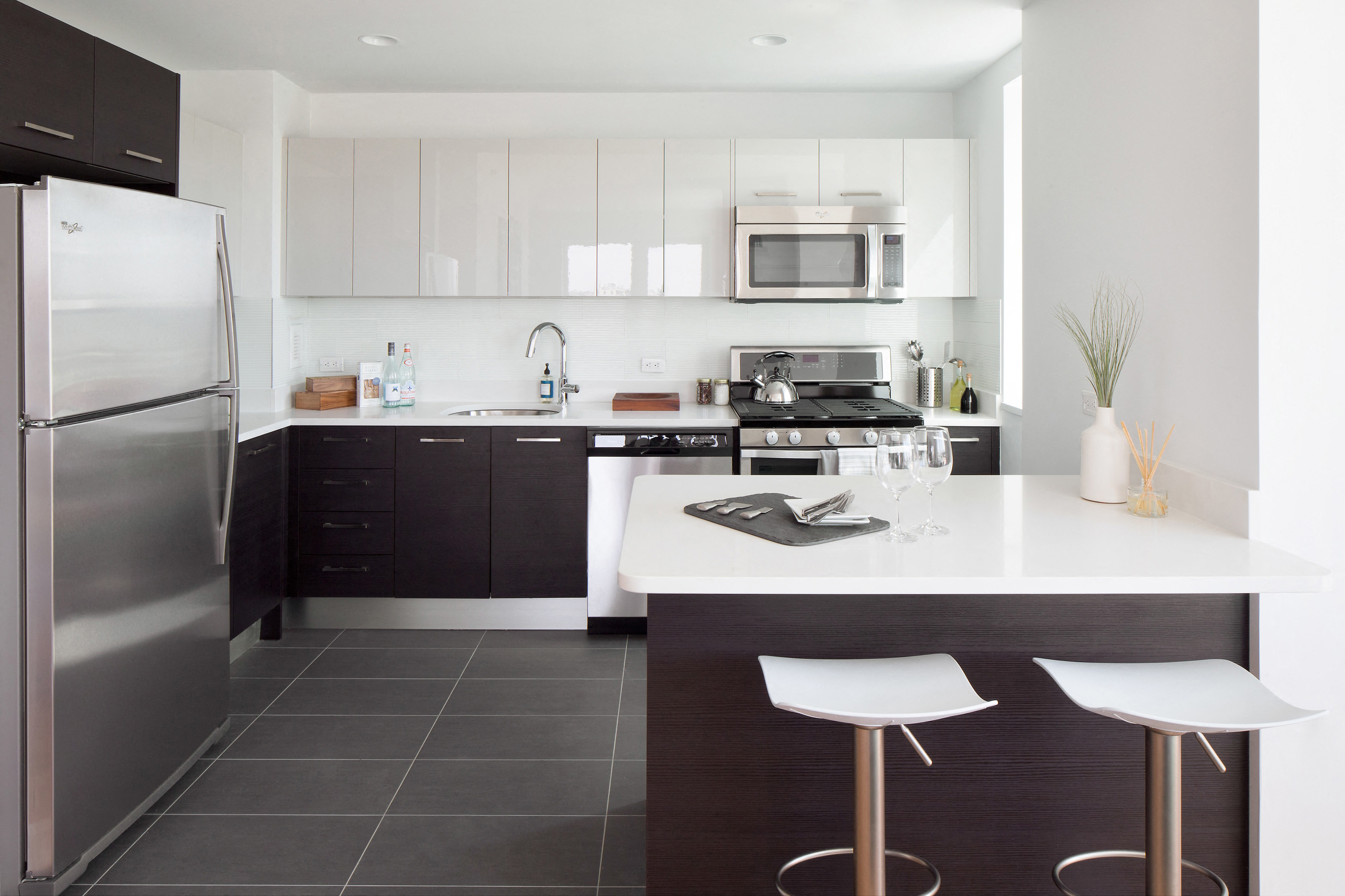 a modern kitchen with stainless steel appliances and a white counter top